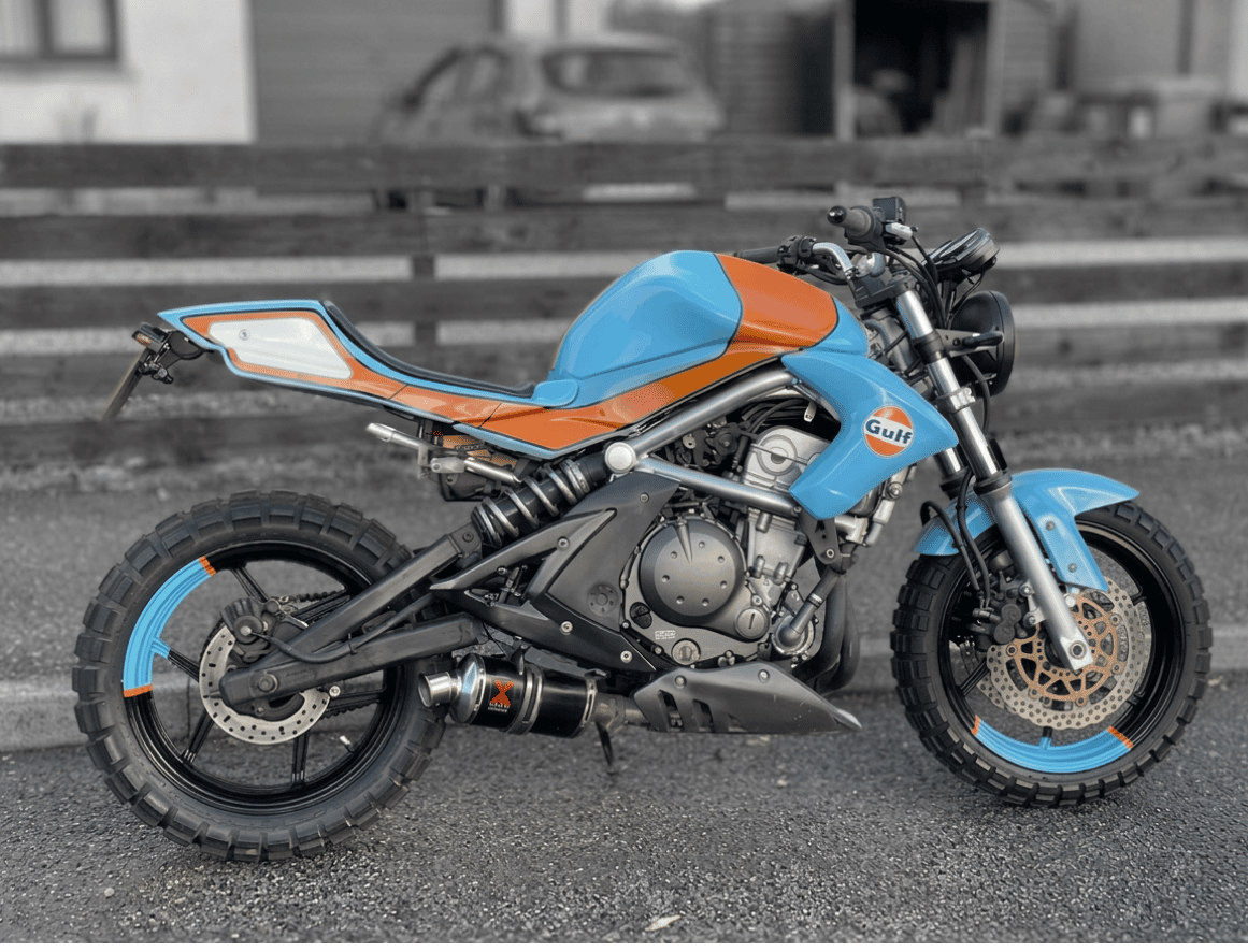 Side view of a custom-built Kawasaki ER-6N Gulf streetfighter against a wooden slatted wall