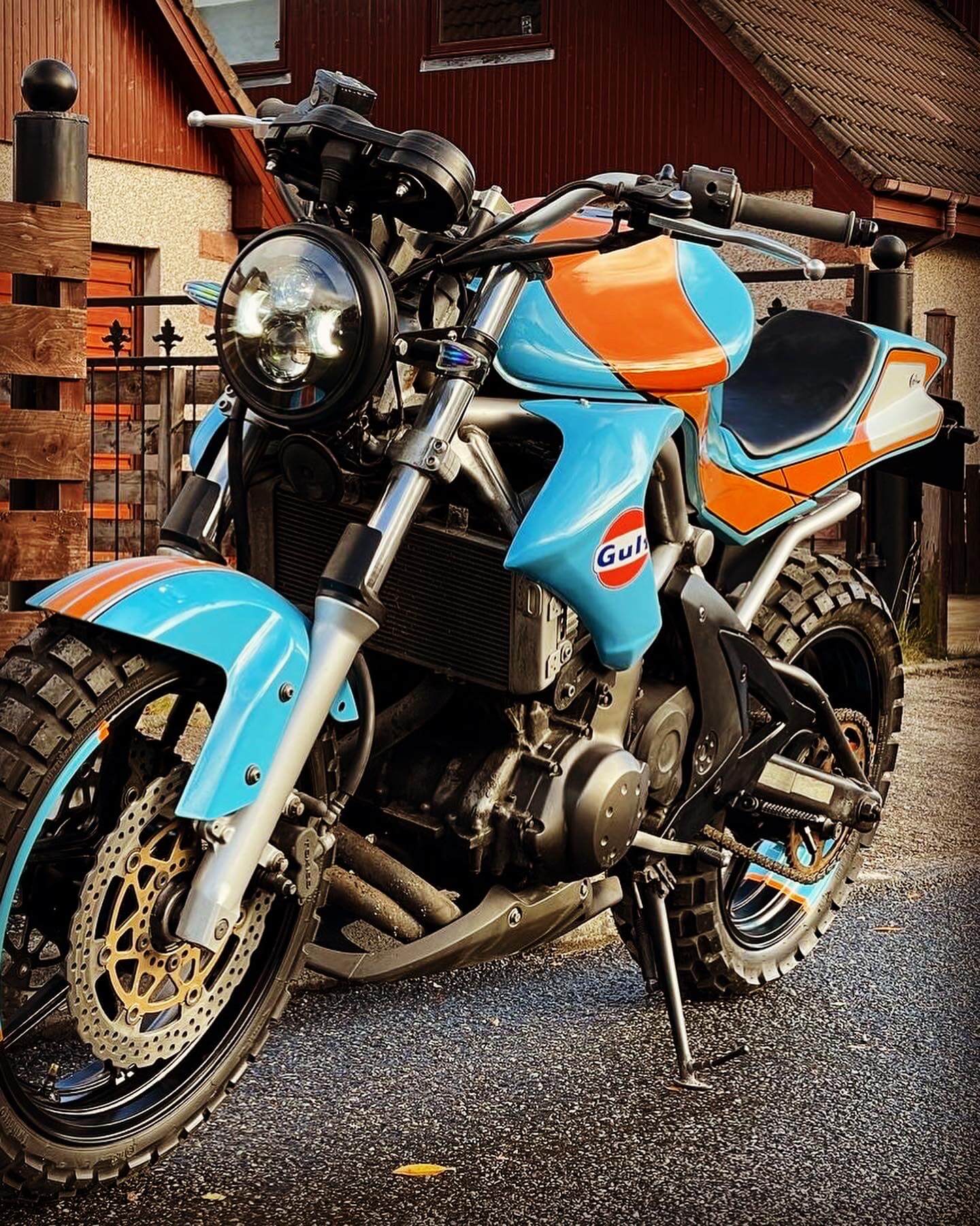 Custom-built Kawasaki ER-6N street tracker in Gulf livery, finished in the Cairngorm Custom Motorbikes workshop